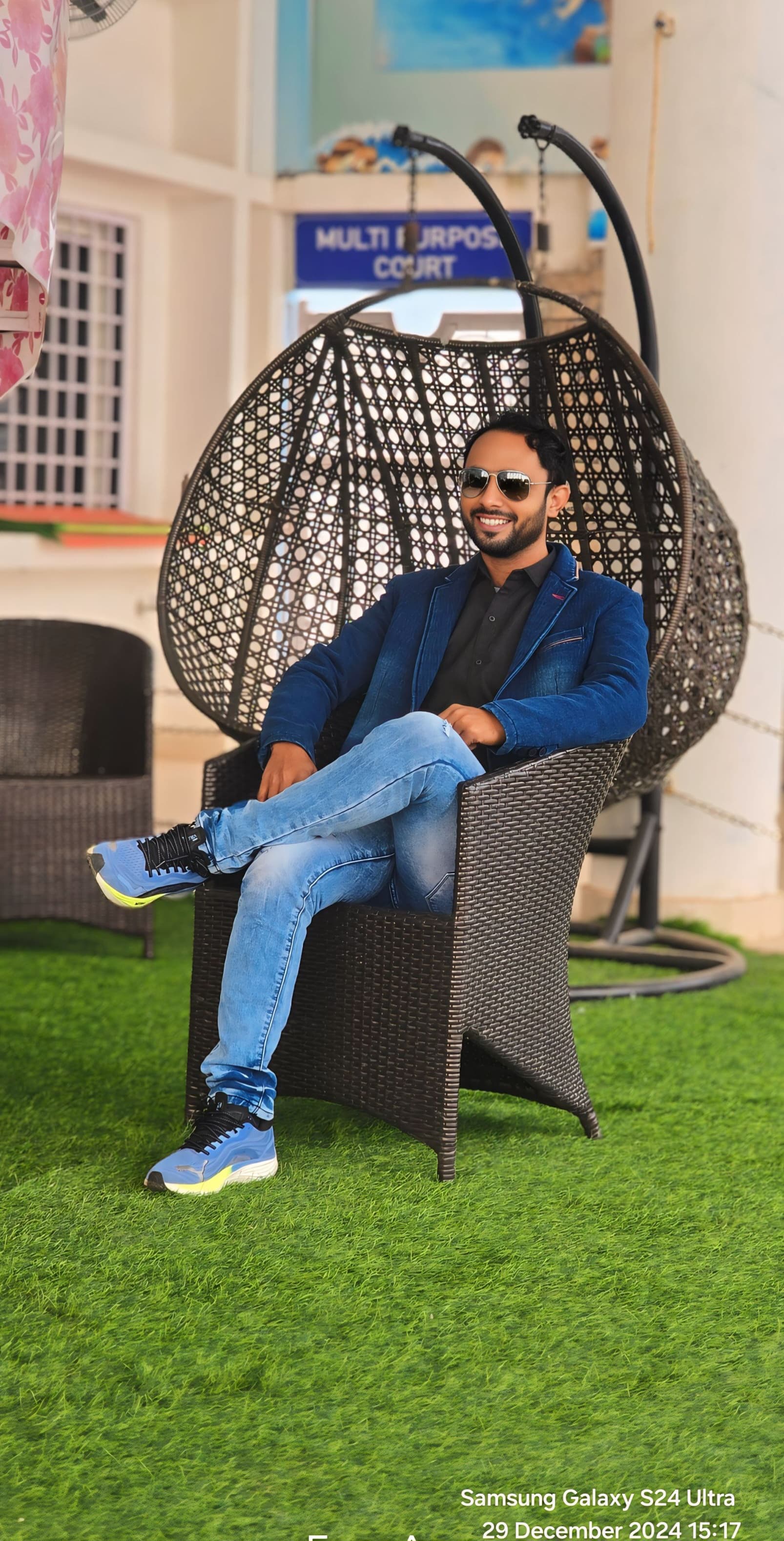 Professional portrait in multi-purpose sports court with modern egg chair - Contemporary sports facility setting