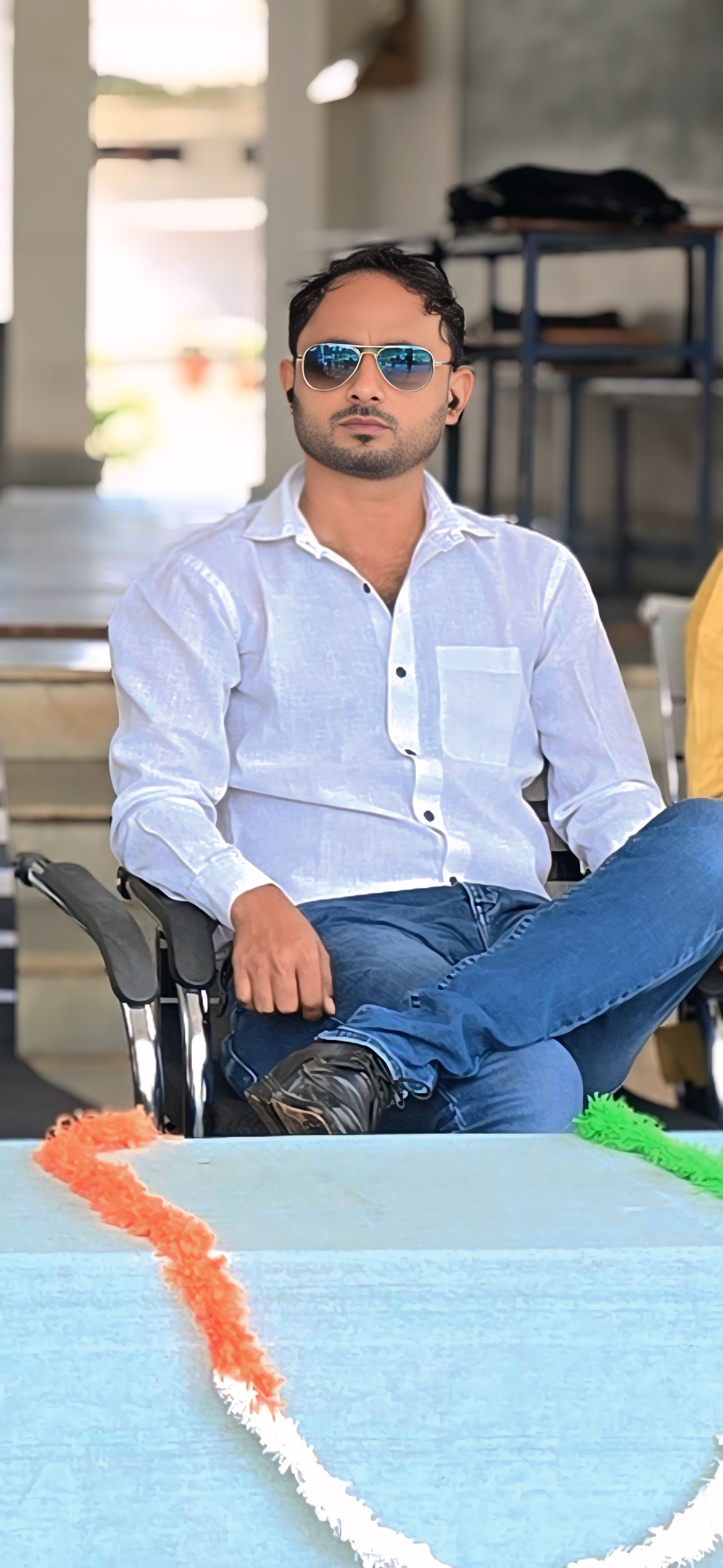 Casual seated portrait in white shirt with sunglasses - Relaxed outdoor setting with natural lighting