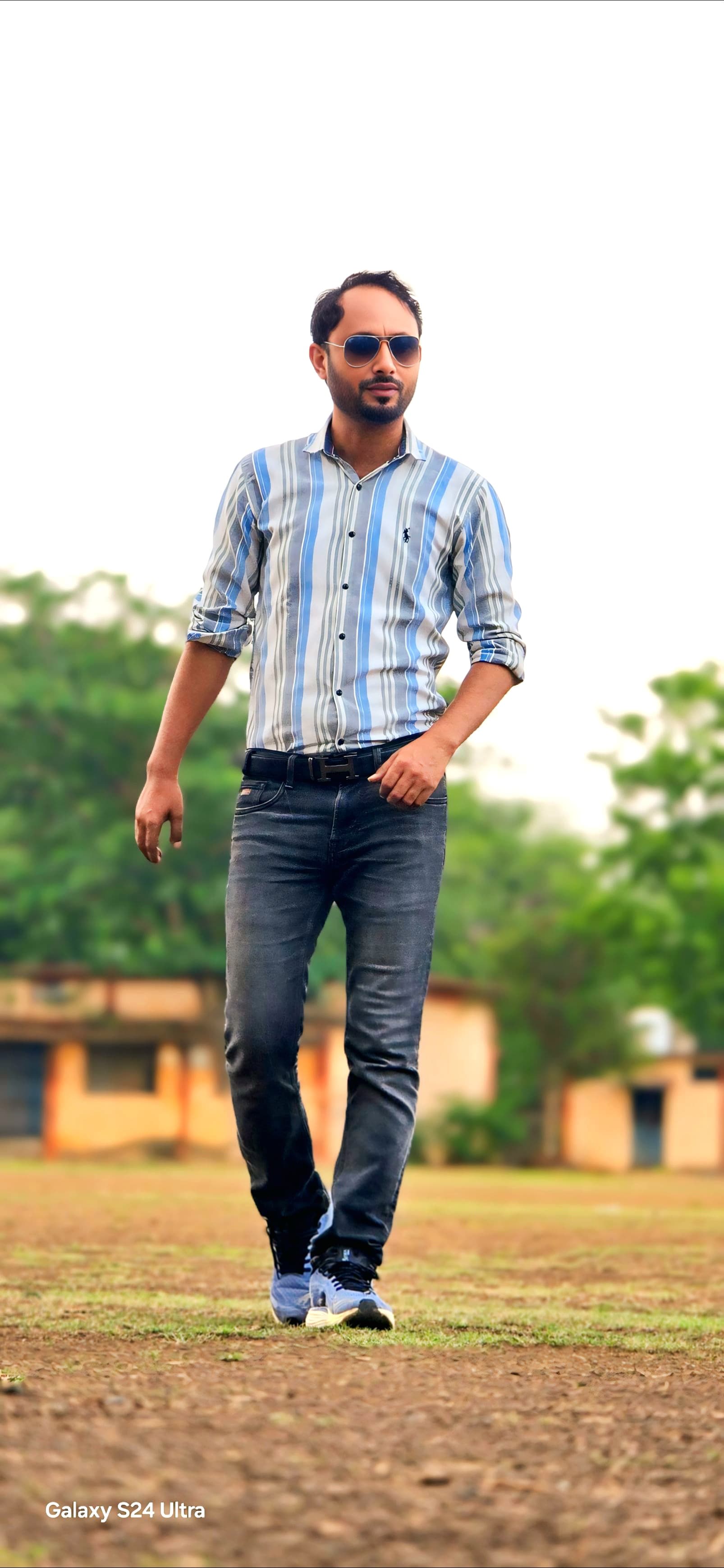 Professional walking portrait in striped blue shirt - Purposeful movement in business casual attire